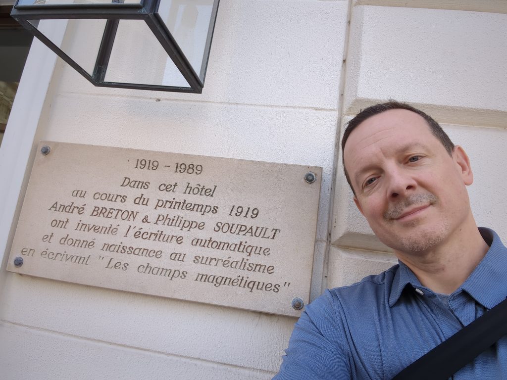 The author, Nick Montfort, standing in front of a plaque commemorating the birthplace of surrealism.